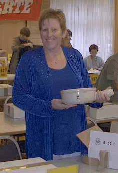 Marylou tenant le prix souvenir de Charmey: un caquelon à fondue